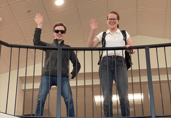 Two Students Waving